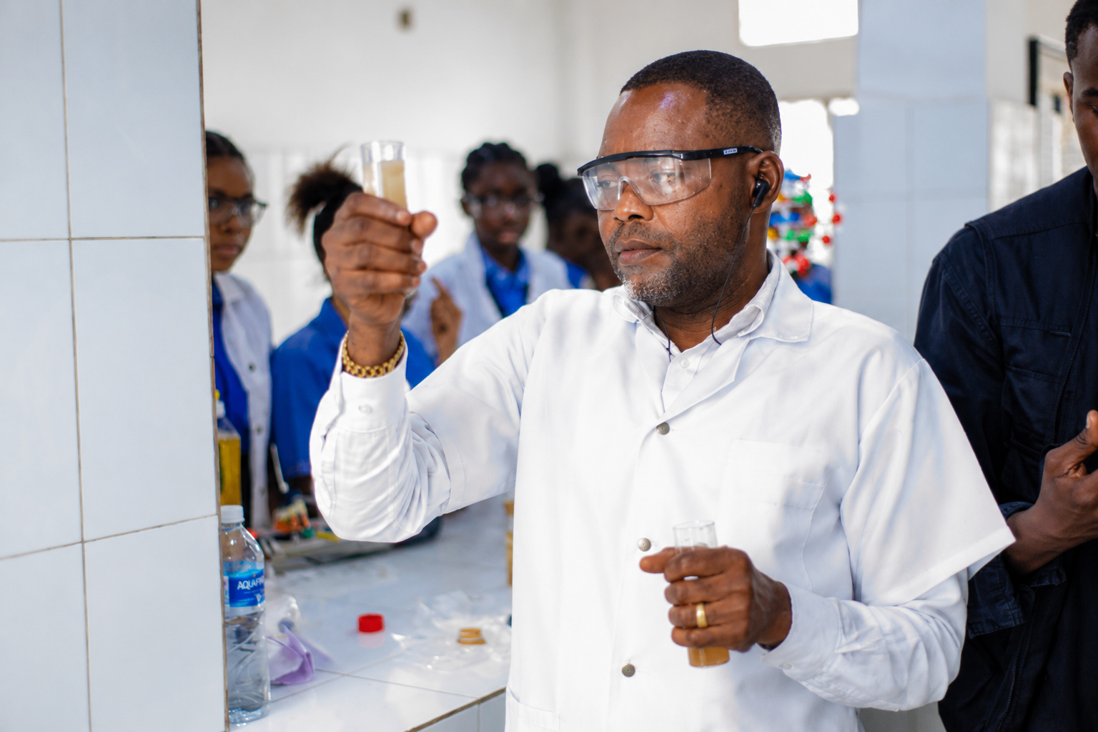 Enseignant observant une éprouvette lors d'un cours de chimie