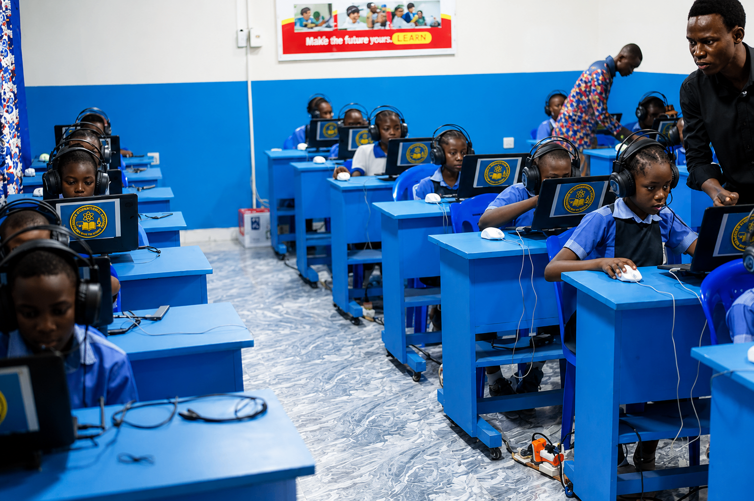 Salle informatique équipée d'ordinateurs bleus avec casques audio